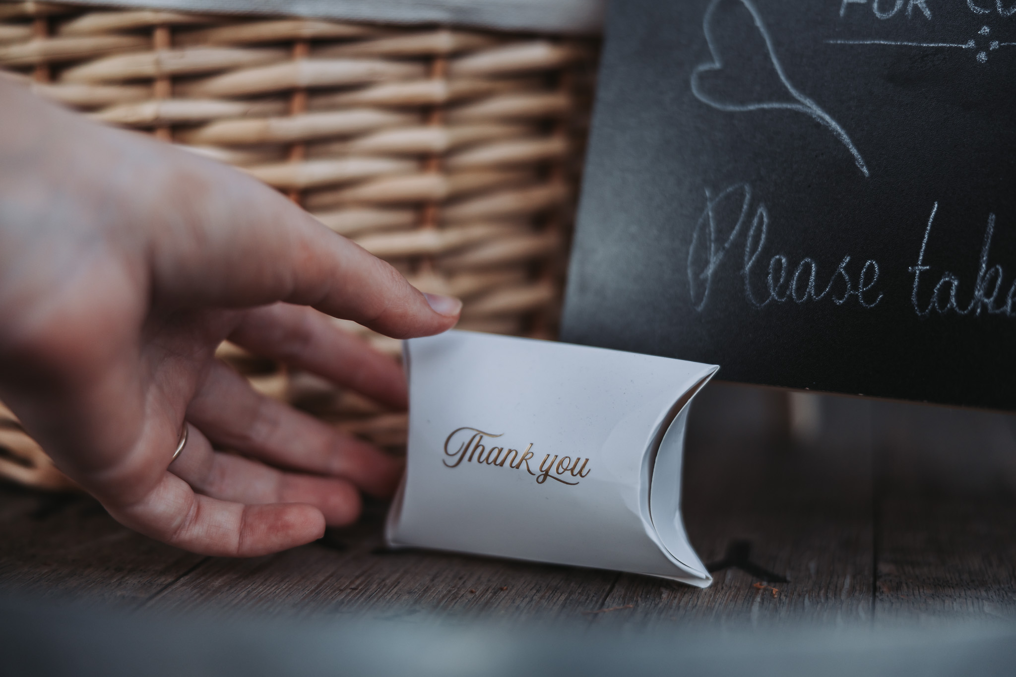 Close-up of a white thank-you favour box on a rustic wooden table at a Perth celebration